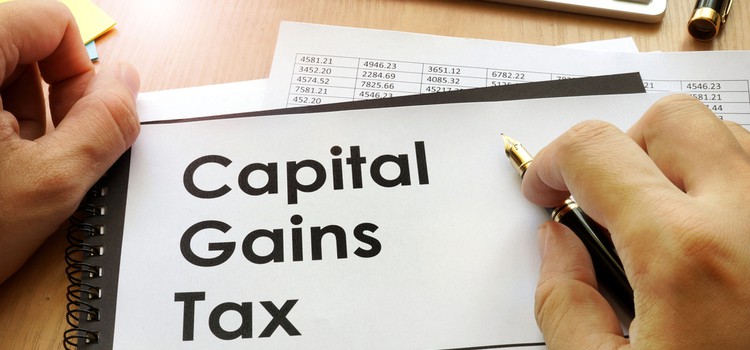 Hands holding a document that says “Capital Gains Tax”