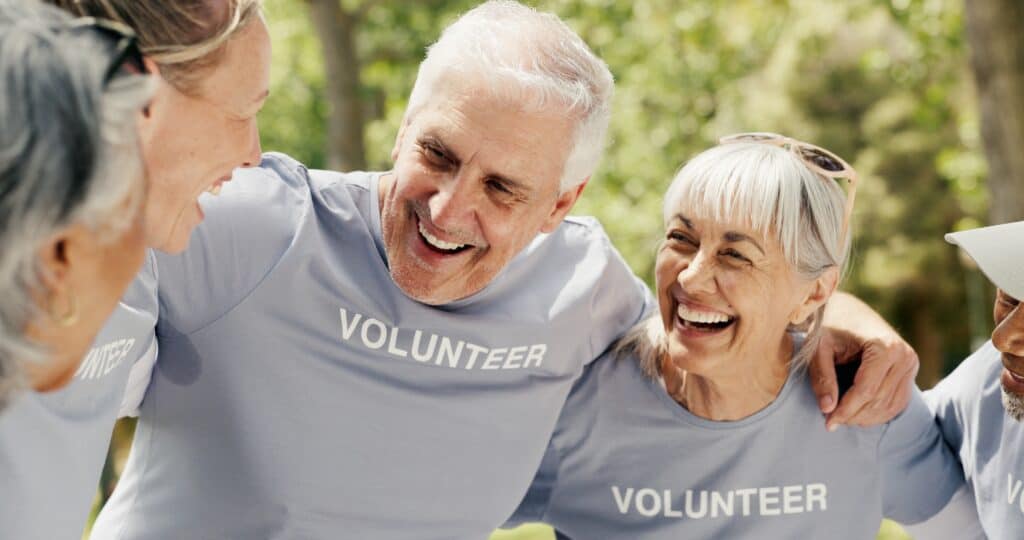: Happy senior people wearing “volunteer” t-shirts.